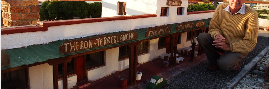 Coenie van Dyk sit hier by sy uitbeelding van 7de Laan in sy tuin in De Kelders wat â€˜n tyd gelede deur die Pasella-span van SABC2 besoek is. Dit word eerskomende Vrydagaand, 22 Mei 2015 om 18:00 gebeeldsend en word Sondag om 14:00 herhaal. Coenie se volledige tuin bestaan uit realistiese uitbeeldings van 7de Laan, â€˜n volledige â€œplaasâ€ met alles wat daarmee saamgaan en veel meer, asook â€˜n spoorwegstasie wat hy onlangs gefinaliseer het. Kyk gerus Vrydagaand of Sondagmiddag na Pasella op SABC2.